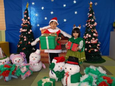 クリスマスのセットの中でポーズするきょうだい